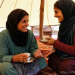 Home 14 요르단에서의 안전한 여행 팁 - **Prompt:** A warm and respectful cultural exchange taking place inside a cozy, traditionally decora...